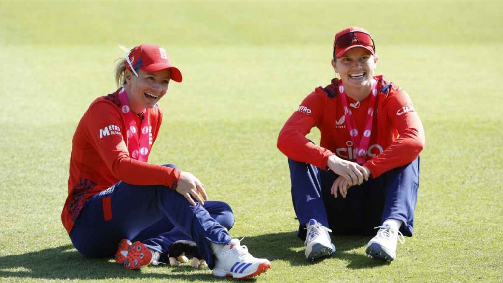 Danni Wyatt-Hodge and Amy Jones sit on the outfield
