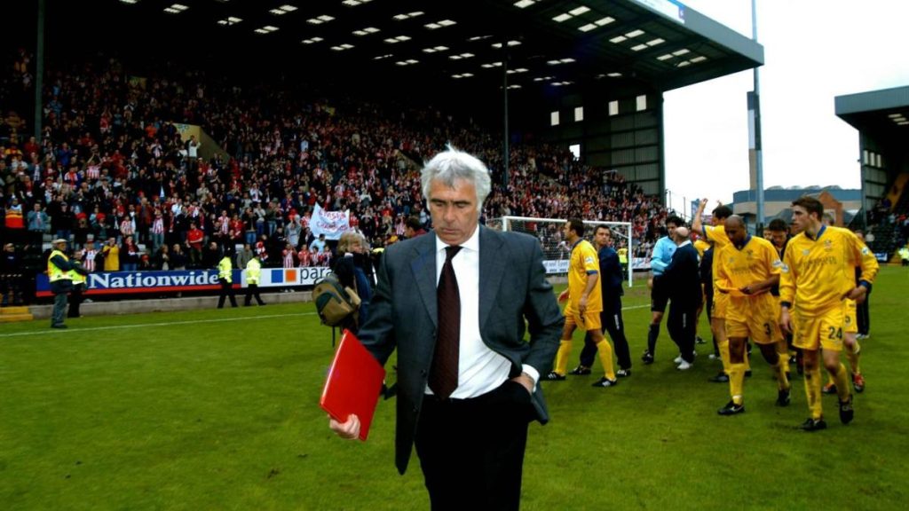 Bobby Gould leads his Cheltenham team off the pitch after a defeat in 2003