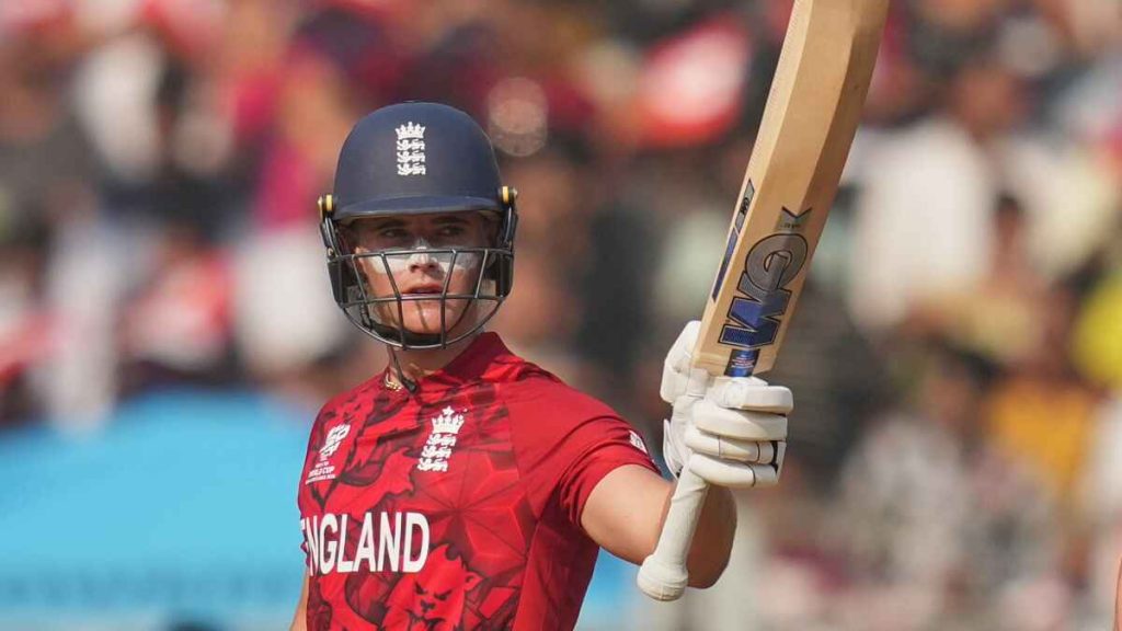 Jacob Bethell raises his bat after reaching his half-century against Nepal