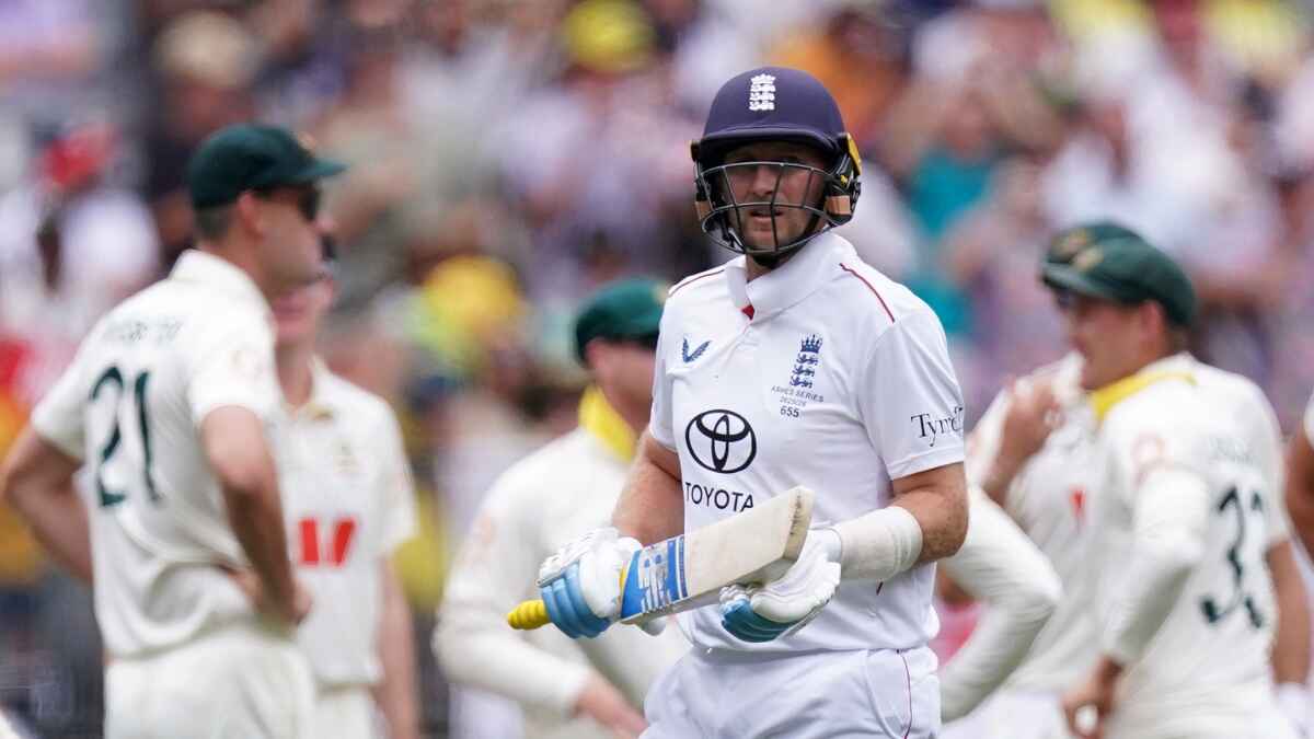 England's Joe Root (centre) walks off after being dismissed by Australia’s Mitchell Starc