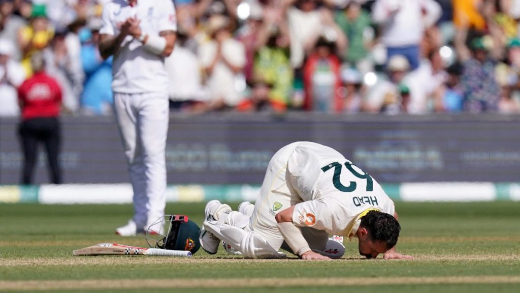 Australia batter Travis Head kisses the ground to celebrate reaching his century