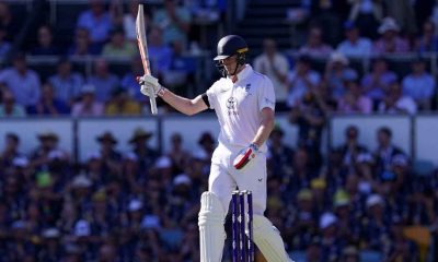 England’s Zak Crawley raises his bat to celebrate reaching his half century on day one of the second Ashes Test in Brisbane